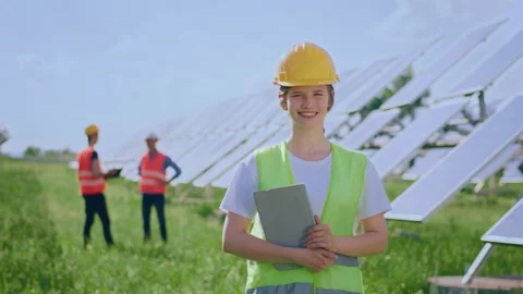 Large smiling ecological engineer woman posing in the middle of photovoltaic Stock Footage 202511289