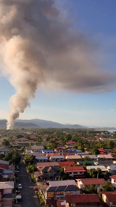Large smoke plume rising over residential town as fire burns near neighborhood Stock Footage 337104738
