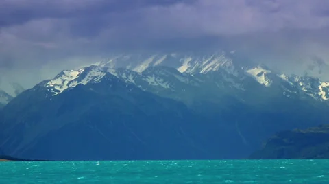 Large snow covered mountain overlooking blue lake. South Island, New Zealand Stock Footage 34344266