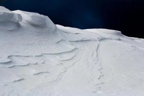 Large snow drift against dark sky Stock Photos