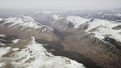 Large snow patch left over on the volcanic rock field of a mountain in summer Ilustración de archivo