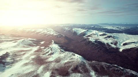 Large snow patch left over on the volcanic rock field of a mountain in summer Ilustración de archivo