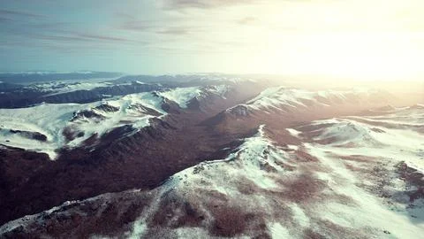 Large snow patch left over on the volcanic rock field of a mountain in summer Ilustración de archivo