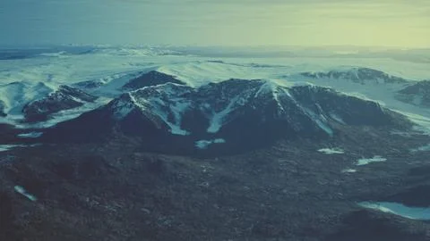 Large snow patch left over on the volcanic rock field of a mountain in summer Stock Illustration