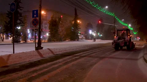 Large snow tractor at work on the evening streets of the city Video stock 320997090