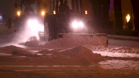 Large snow tractor at work on the evening streets of the city Stock Footage 321611980