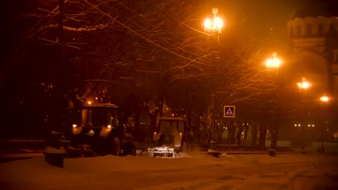 Large snow tractor at work on the evening streets of the city Stock Footage 321612584