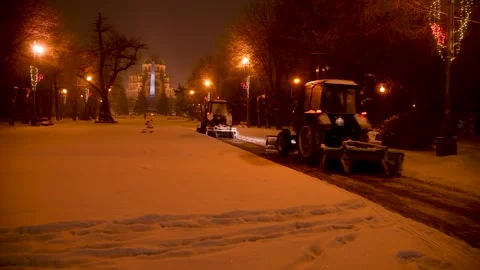 Large snow tractor at work on the evening streets of the city Stock Footage 321612585