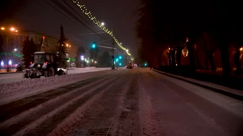 Large snow tractor at work on the evening streets of the city Stock Footage 342388137