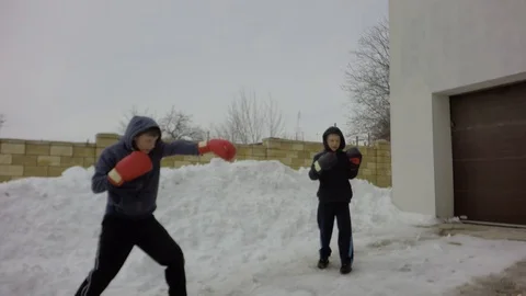 A large snowdrift. Two boys are training. A fight with a shadow. 库存影片 87739362
