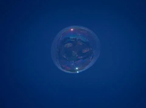 Large soap bubble with reflection in the blue sky Stock Photos