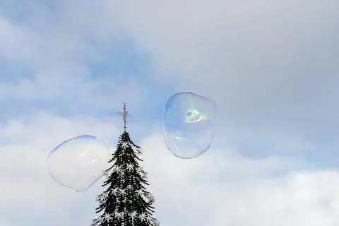 Large soap bubbles float above Christmas tree Lisbon sky Stockfoto's