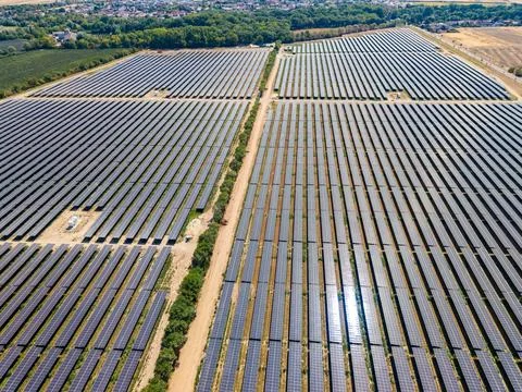 Large solar farm located in an open area showing rows of solar panels under.. Foto stock