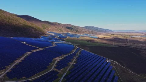 Large solar farm in open field near mountains during daytime Stockbeeldmateriaal 334035209
