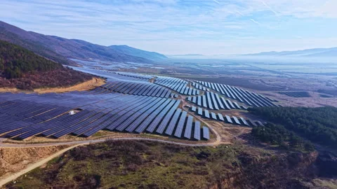 Large solar panel array covers a valley in the mountains with clear skies and Stock Footage 335422468
