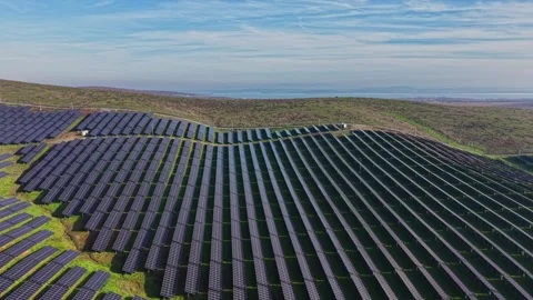Large solar panel array on hillside under blue sky and clouds Stock Footage 330000885