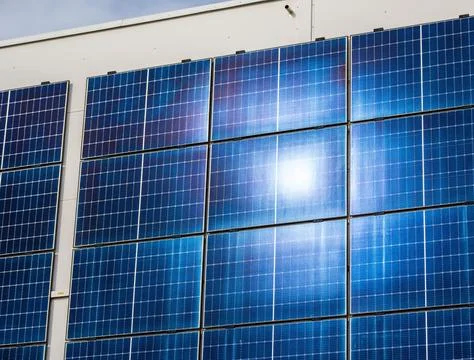 Large solar panel array on industrial building facade. Fotos de archivo