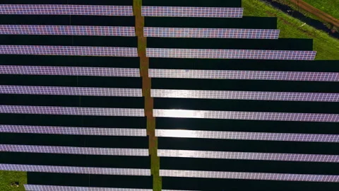 Large solar panel array installed on a grassy field for renewable energy Stock Footage 336531726