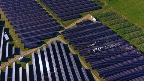 Large solar panel array located in a field with multiple rows of panels under Stock Footage 331100695