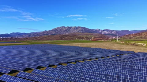 Large solar panel array in rural area with mountains in the background during Stock Footage 331153428