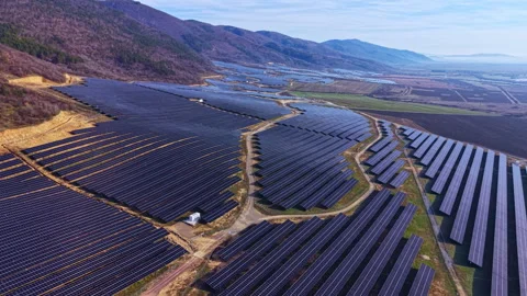 Large solar panel array in rural location during daytime with mountains in the Stock Footage 335357522