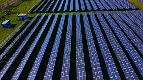 Large solar panel array in a rural area generates renewable energy for local Stock Footage 335401044
