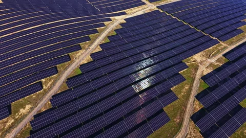 Large solar panel array in a rural area with multiple rows of panels capturing Stock Footage 336592386