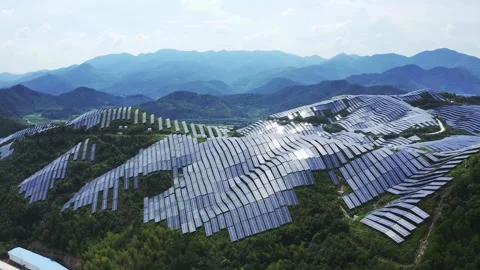 Large solar panel farm on green hills generates energy Vídeo Stock 333817528