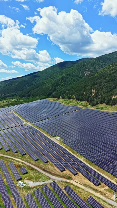 Large solar panel farm located in a valley surrounded by mountains with bright 스톡 동영상 341127336