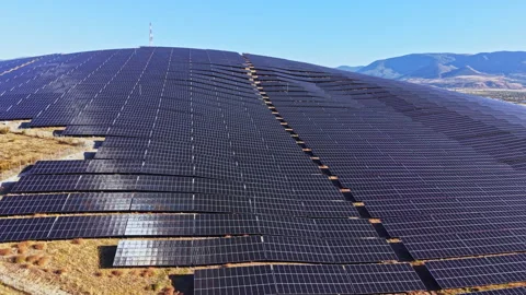 Large solar panel installation on a hill with sunny skies in the background and Stock Footage 347758299