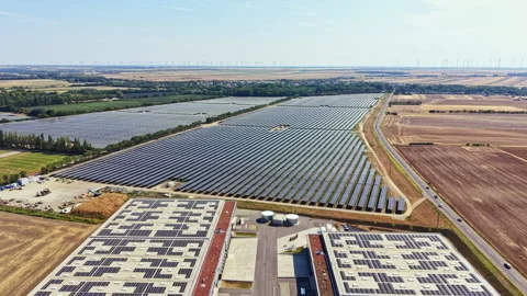 Large solar panel installation near a rural area with fields and wind turbines Stock Footage 342734820