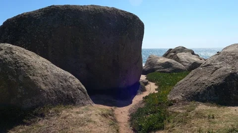 Large, solid rocks forming a path to the beach in Porto, Portugal on a sunny Stock Footage 282255334