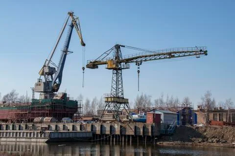 Large spacious dry-cargo barge with cranes on the blue sky background Stock Photos