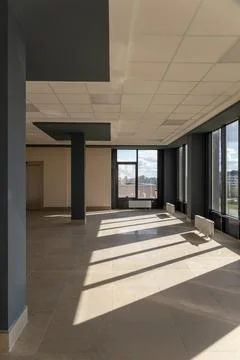 A large, spacious, empty room with huge windows and floor-mounted central h.. 写真素材