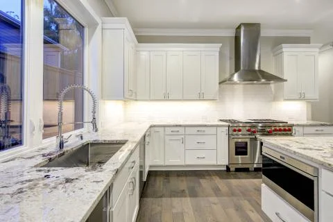 Large, spacious kitchen design with white kitchen cabinets, white kitchen isl Stock Photos