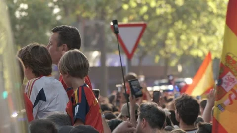 A large Spanish flag waves above a dense crowd of supporters during the Stock Footage 340921737