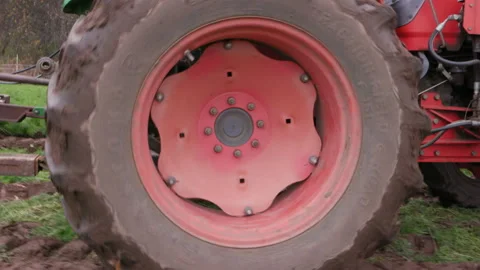 A large, spinning red wheel and tractor tire Stock Footage 159016132
