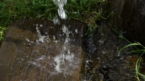 Large splashes and drops of water falling in slow motion on wooden boards Stock Footage 117174007