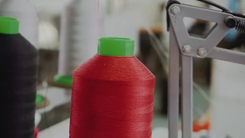 Large spool with red threads on sewing machine in workshop Stock Footage 236907583