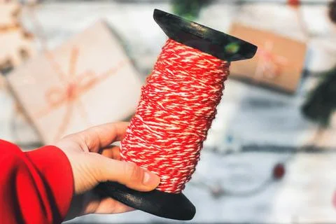 Large spool of thread. Red and white thread for wrapping gifts. Festive mood. Stock Photos