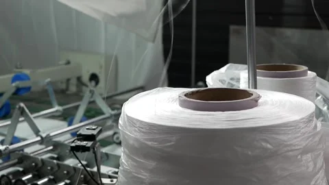  A large spool of thread is unwound on an industrial sewing machine Stock Footage 153800952