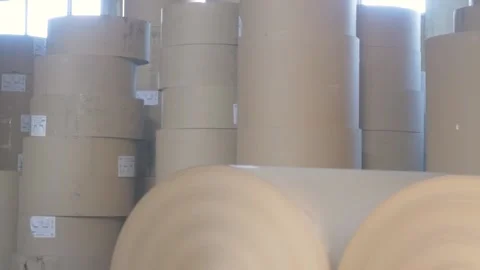 Large spools of brown paper stand in kraft paperboard and box production Stock Footage 233659875