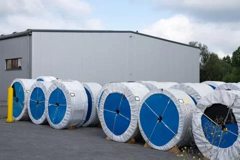 Large spools of material stored outside a modern warehouse Stock Photos