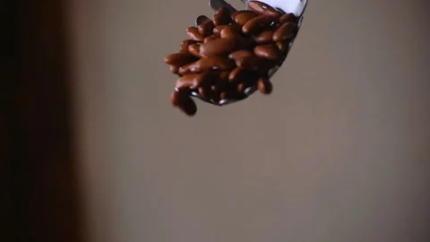 Large spoon dropping multiple Red Kidney Beans in Slow Motion Close Up Stock Footage 339971723