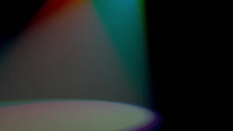 A large spot of light from the merging of multicolored beams of spotlights moves Stock Footage 153163795