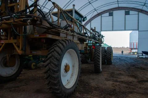 Large sprayer tractor inside a hoop barn on a farm. Stock Photos