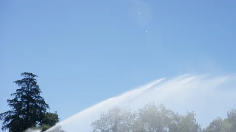 Large sprinkler system spraying water stream watering open field by road C Video stock 112883934