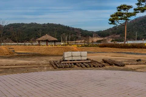Large square boulder on logs in neolithic park. Stock Photos