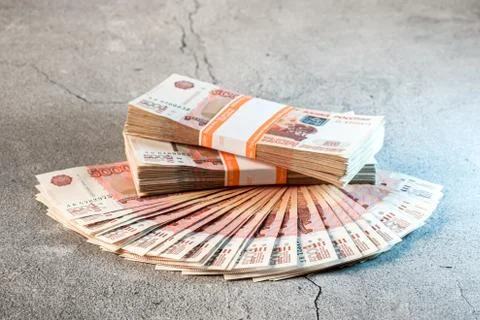 Large stack of banknotes, Russian rubles laying on a grey concrete surface Stock Photos
