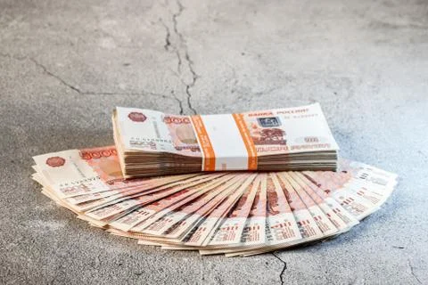 Large stack of banknotes, Russian rubles laying on a grey concrete surface Stock Photos